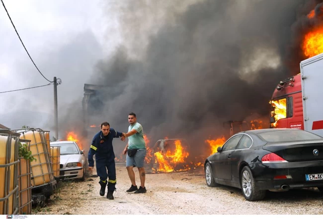 Συγκλονιστική φωτογραφία πυροσβεστη που προσπαθει να απομακρύνει πολιτη που βλέπει το αυτοκίνητο του να φλέγεται.jpg 2