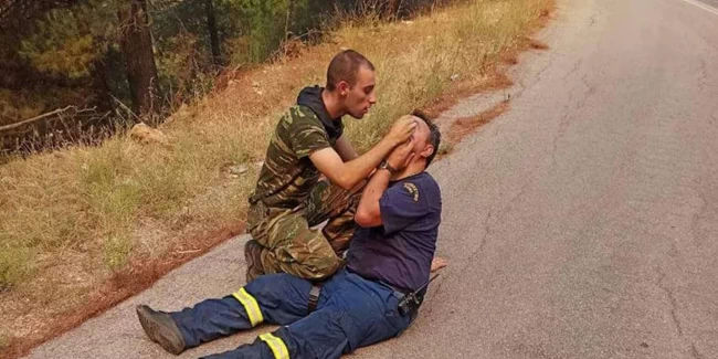 Συγκλονιστική φωτογραφία: Στρατιώτης παρέχει πρώτες βοήθειες σε πυροσβέστη