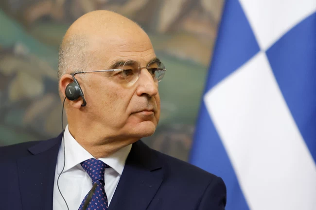 Δένδιας με φόντο σημαία