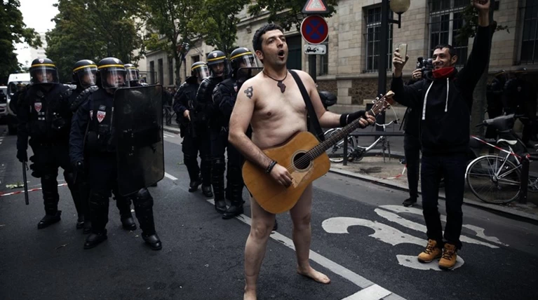 Ο γυμνός διαδηλωτής του Παρισιού -Επαιζε κιθάρα μέσα στον χαμό [βίντεο]